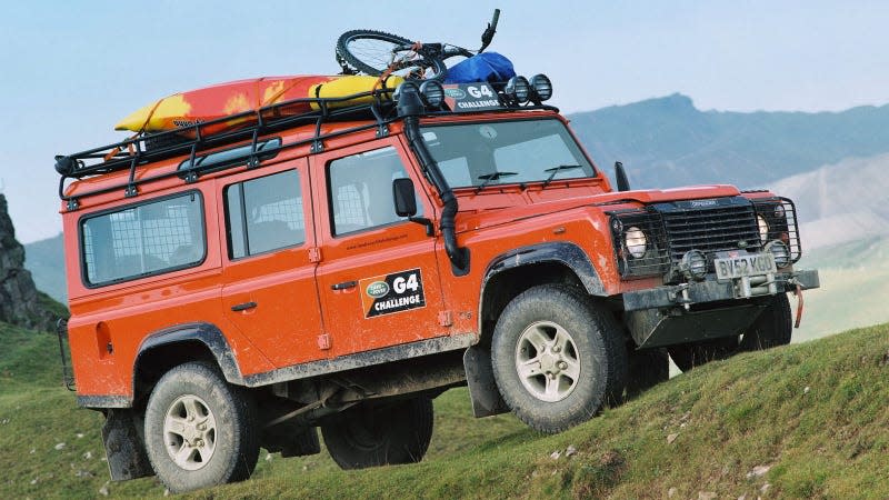 A photo of an orange Land Rover Defender 110. 
