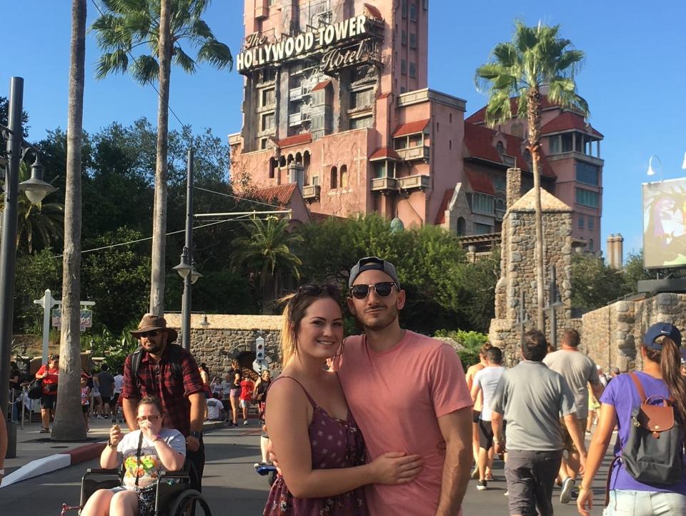 hayley and her partner posing in front of tower of terror in hollywood studios