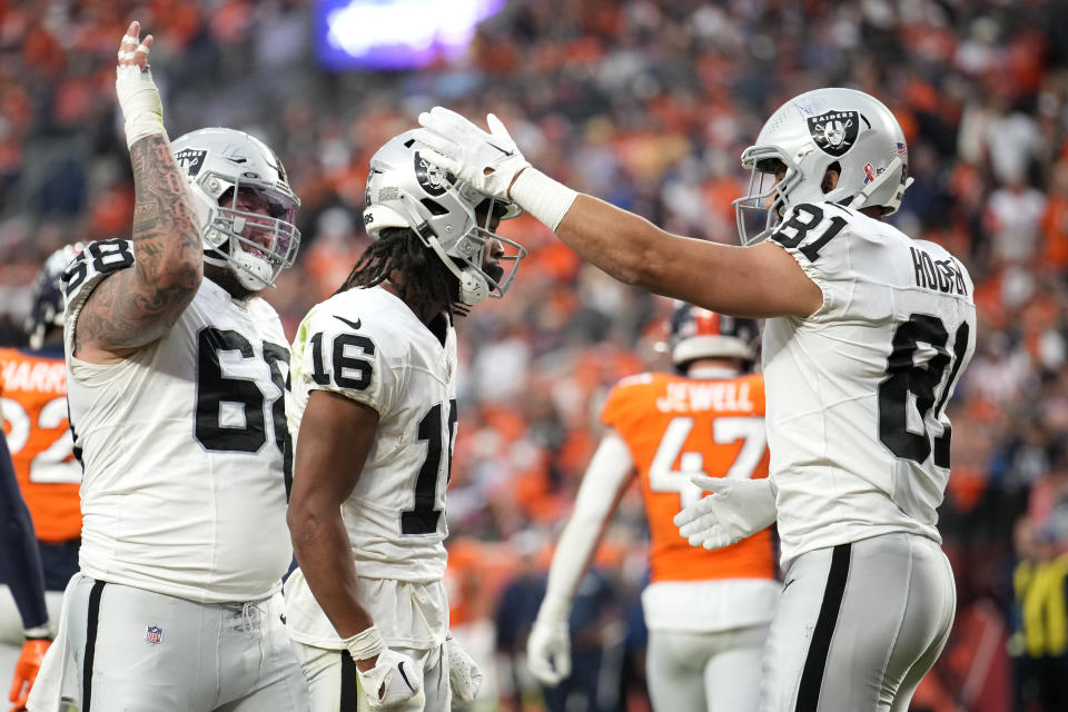 Las Vegas Raiders wide receiver Jakobi Meyers (16) celebrates his touchdown catch against the Denver Broncos with Raiders center Andre James, left, and Raiders tight end Austin Hooper (81) during the second half of an NFL football game, Sunday, Sept. 10, 2023, in Denver. (AP Photo/David Zalubowski)
