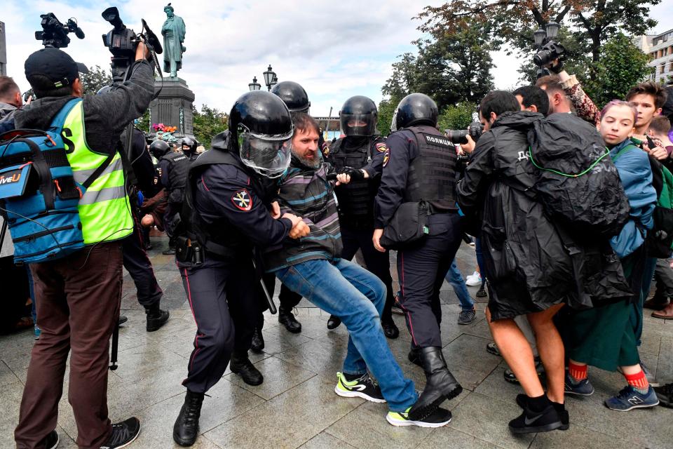 Riot police officers detain a participant of an unsanctioned rally urging fair elections at Moscow's Pushkinskaya Square on August 3, 2019. - The rally is the latest in a series of demonstrations after officials refused to let popular opposition candidates run in next month's city parliament elections.