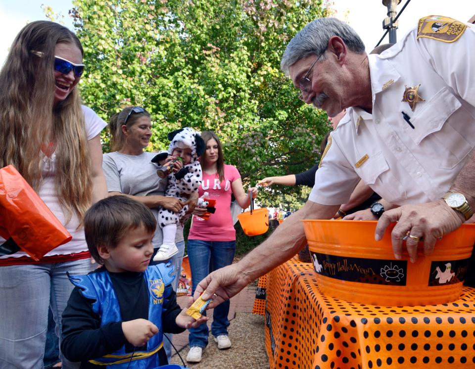 Autauga County Chief Deputy Sheriff Joe Sedinger, right, hands out candy in front of Prattville City Hall during the annual Halloween Candy Walk in Prattville on Oct. 29, 2013.