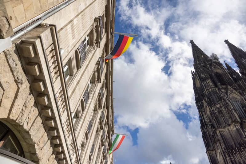 The German and Italian flags fly on the facade of Hotel Excelsior. Thomas Banneyer/dpa