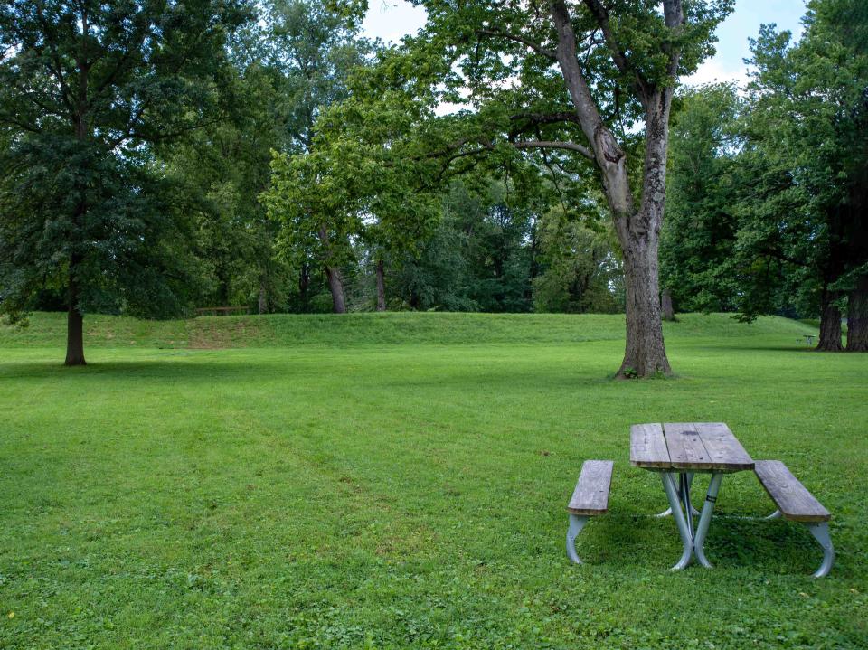 An empty picnic table by the exterior of the Great Circle at the Newark Earthworks built by prehistoric indigenous people in Ohio.