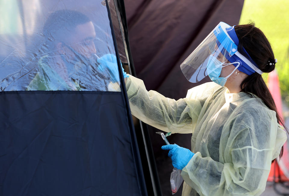 A health care worker administers a COVID-19 test.