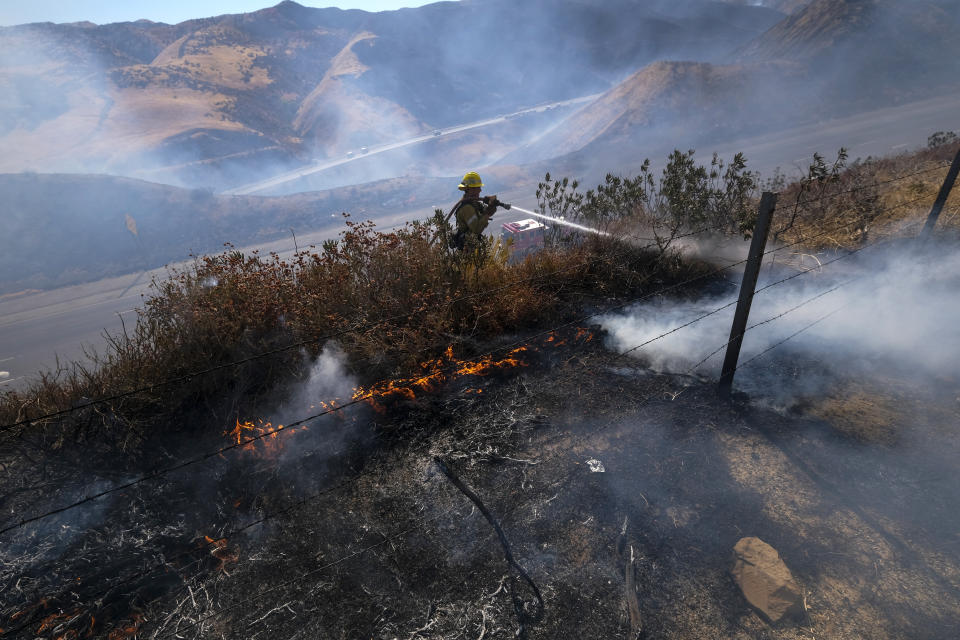 A firefighter works on hotspots while battling a wildfire in Castaic, Calif. on Wednesday, Aug. 31, 2022. (AP Photo/Ringo H.W. Chiu)