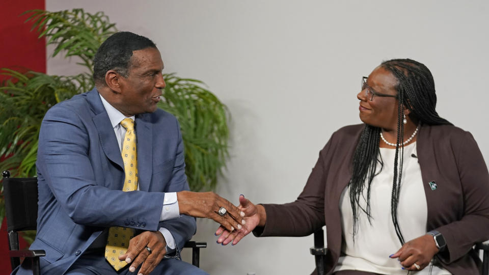 U.S. Rep. Burgess Owens, left, and Democrat Darlene McDonald shake hands following their debate Friday, Oct. 28, 2022, in South Jordan, Utah, in their first and only meeting in the lead-up to the midterm elections. First-term Republican Owens elected not to participate in a televised Utah Debate Commission event earlier this month. (AP Photo/Rick Bowmer)