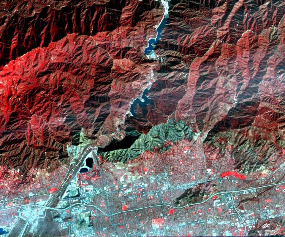 On Jan. 16, 2014, a wildfire broke out in the mountains above the Los Angeles suburbs of Glendora and Azusa. The fire consumed almost 2,000 acres and destroyed several homes, after starting from an illegal campfire. This image, acquired Jan. 23, 2014 from the ASTER instrument on NASA's Terra spacecraft, depicts vegetation in shades of red. The burned area is seen as the blue-gray area at the base of the mountains.