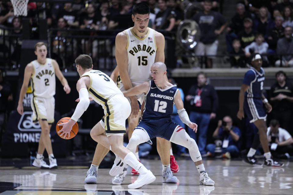 Purdue center Zach Edey (15) sets a pick for guard Braden Smith (3) on Samford guard Dallas Graziani (12) during the first half of an NCAA college basketball game in West Lafayette, Ind., Monday, Nov. 6, 2023. (AP Photo/Michael Conroy)