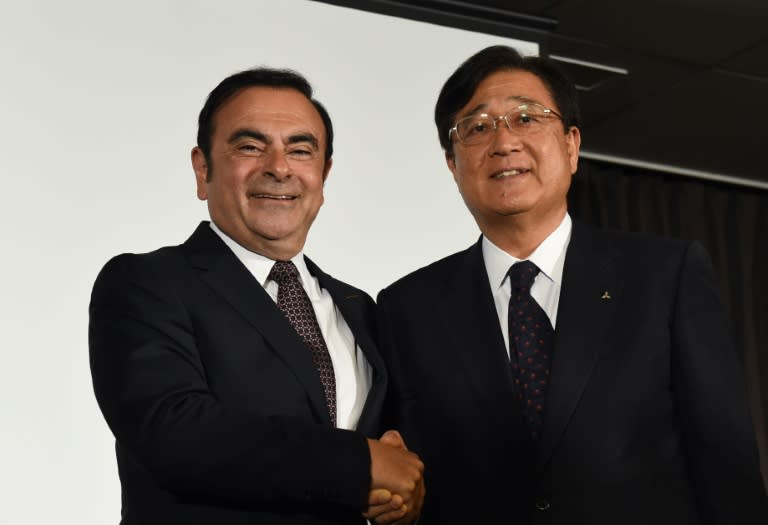 Nissan chief Carlos Ghosn (left) shakes hands with Mitsubishi Motors chairman Osamu Masuko after talks in Yokohama, on May 12, 2016