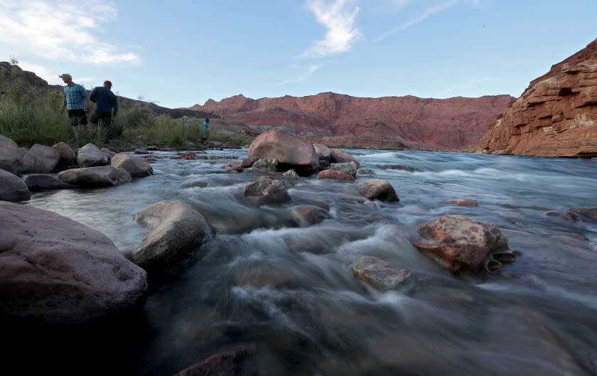 LEE'S FERRY, ARIZONA - MAY 16, 2022. The Colorado River flows over rocks along its banks at Lee's Ferry, a narrow stretch that marks the divide between the river's upper and lower basins. Measurements of Colorado River water flowing through Lee's Ferry are used to factor water allocations to the seven U.S. and two Mexican states in the entire Colorado River Basin. (Luis Sinco / Los Angeles Times)