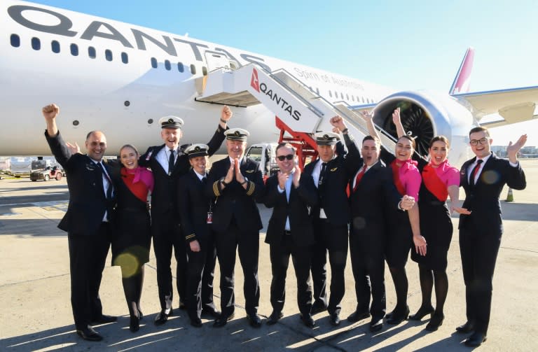 El director general de Qantas, Alan Joyce (c), rodeado de miembros de la tripulación del vuelo más largo de la historia sin escalas posan delante del avión, el 20 de octubre de 2019 en Sídney