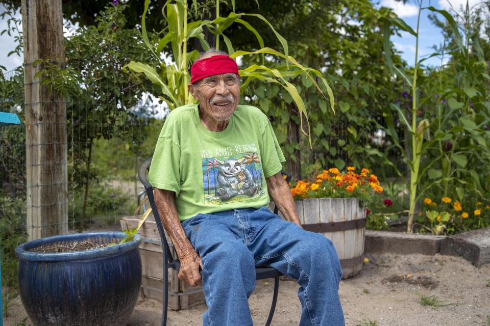 Raymond Naranjo, 99, poses for a photo outside his home in Santa Clara Pueblo in northern New Mexico, Monday, Aug. 22, 2022. Pueblo elders say ancestral knowledge is key for future generations to develop a strong cultural and spiritual connection to this ancient place to help preserve their way of life. (AP Photo/Andres Leighton)