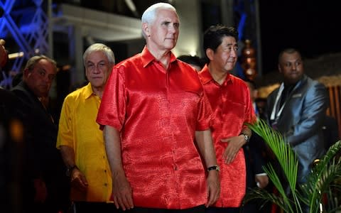 Japan's Prime Minister Shinzo Abe (R) and the US Vice President Mike Pence arrive for a "family photo" - Credit: Saeed Khan/AFP