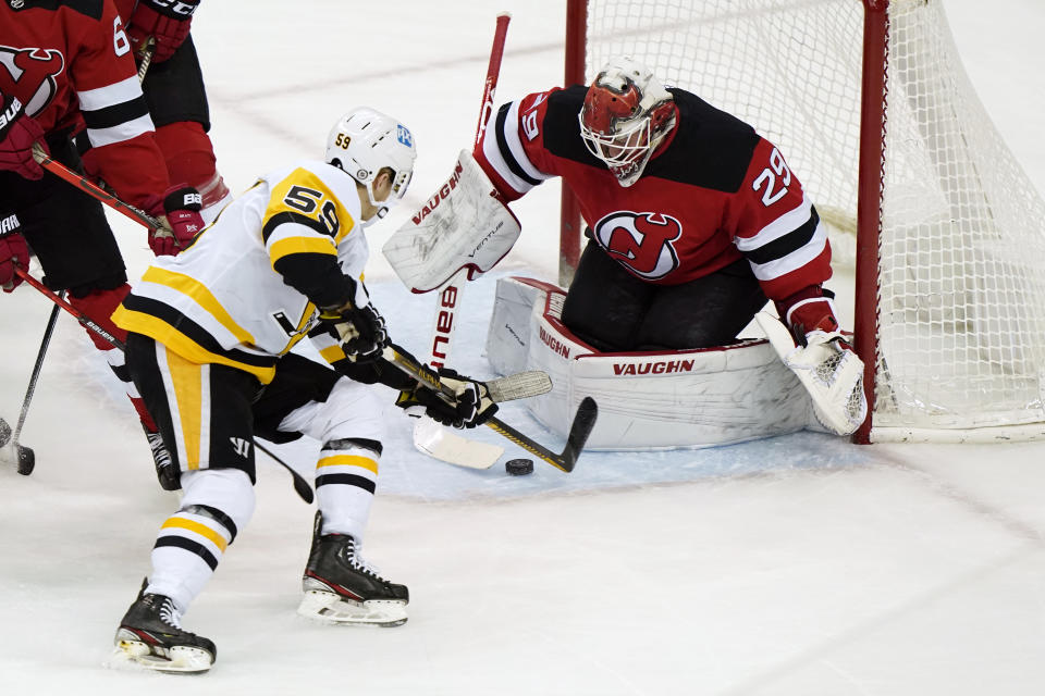 Pittsburgh Penguins left wing Jake Guentzel (59) tries to score in front of New Jersey Devils goaltender Mackenzie Blackwood (29) during the first period of an NHL hockey game, Sunday, April 11, 2021, in Newark, N.J. (AP Photo/Kathy Willens)