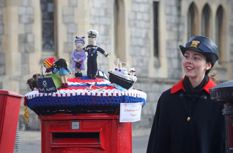 <p>A warden looks at a knitted tapestry created by the Ickenham Postbox Toppers, in honour of the Duke of Edinburgh award, atop a post box in Windsor, Berkshire, following the death of the Duke of Edinburgh at the age of 99 on April 9. Picture date: Friday April 16, 2021.</p>
