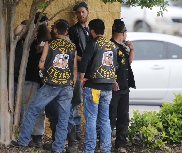 Bikers congregate against a wall while authorities investigate a Twin Peaks restaurant Sunday, May 17, 2015, in Waco, Texas. Waco Police Sgt. W. Patrick Swanton told KWTX-TV there were &quot;multiple victims&quot; after gunfire erupted between rival biker gangs at the restaurant. (Rod Aydelotte/Waco Tribune-Herald via AP)