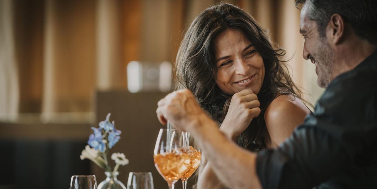 happy mature couple enjoying drink in restaurant