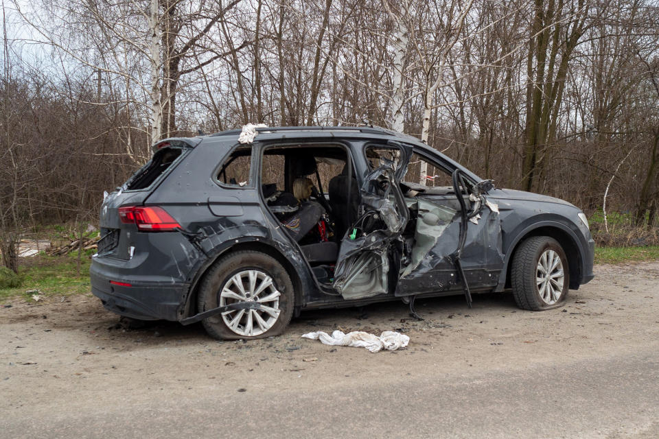 A damaged car is left by the roadside in the town of Havronshchyna. (Mo Abbas / NBC News)