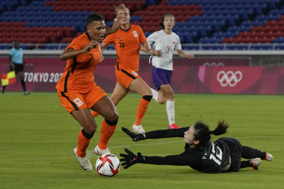 Netherlands' Shanice van de Sanden, left, dribbles the ball to score her side's opening goal as China's Peng Shimeng tries to stop during a women's soccer match at the 2020 Summer Olympics, Tuesday, July 27, 2021, in Yokohama, Japan. (AP Photo/Kiichiro Sato)