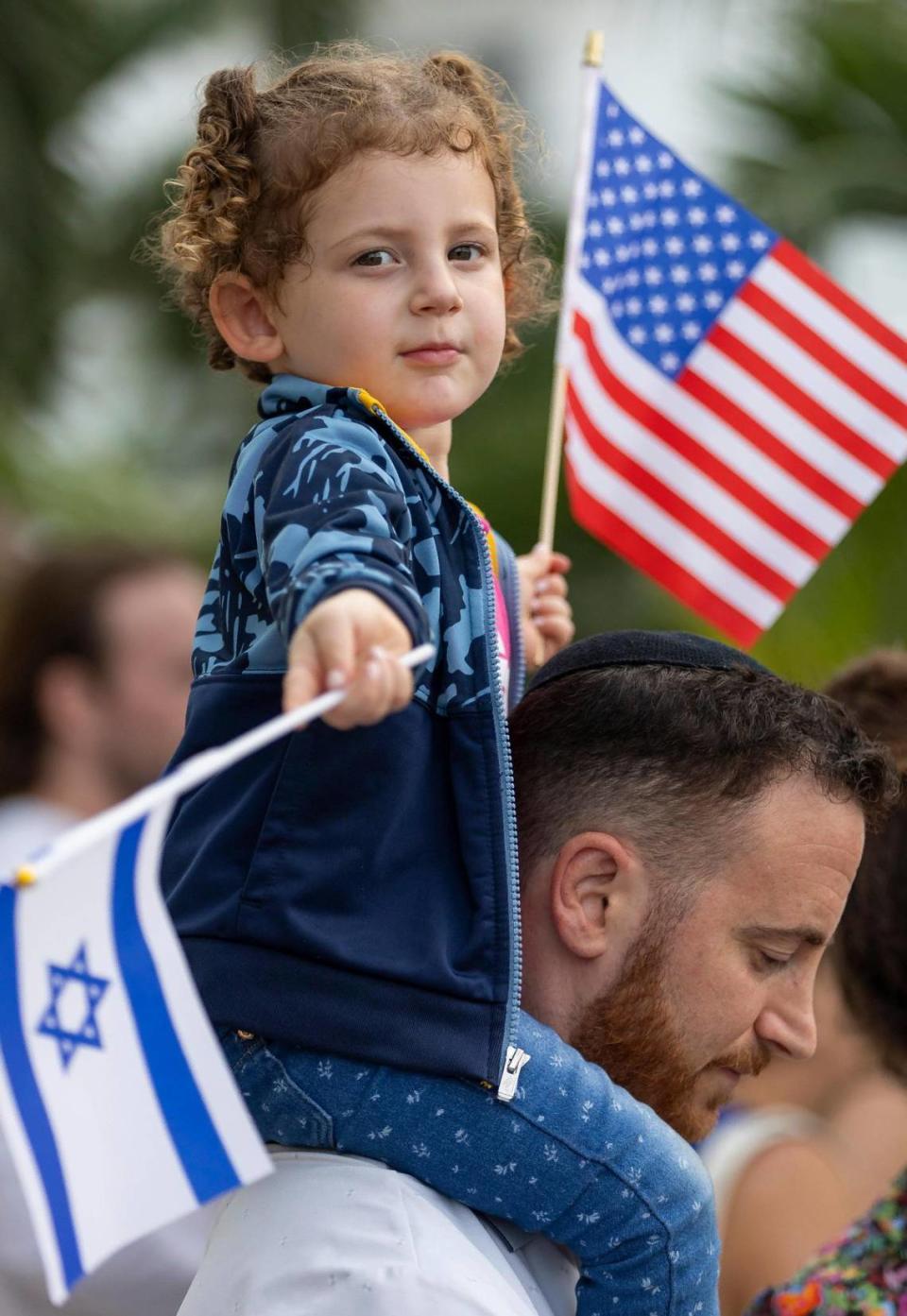 Fay, de 3 años, sentada sobre los hombros de su padre, Menachem, de 33, en la concentración en el Monumento al Holocausto, el martes 10 de octubre de 2023, en Miami Beach, Florida.