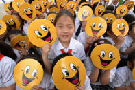 Primary school students in Yongchuan District hold boards of smiling faces to welcome the upcoming World Smile Day on May 5, 2016 in Chongqing, China. (VCG/VCG via Getty Images)