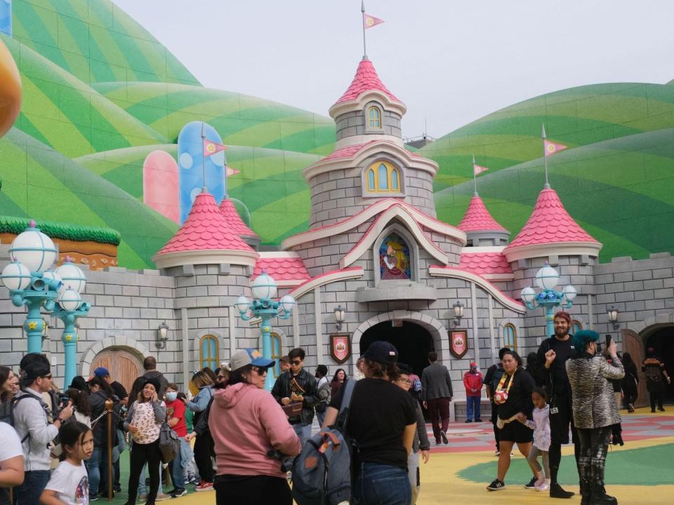 Guests walk by Princess Peach's castle during a preview of Super Nintendo World at Universal Studios in Los Angeles, California, on January 13, 2023.