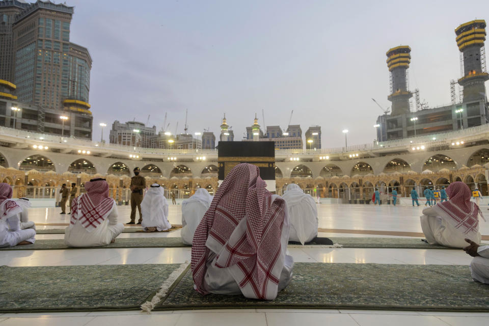 Pilgrims pray around the Kaaba, the square structure in the Great Mosque, toward which believers turn when praying, in Mecca, Saudi Arabia, late Sunday, July 26, 2020. Anywhere from 1,000 to 10,000 pilgrims will be allowed to perform the annual hajj pilgrimage this year due to the virus pandemic. (Saudi Ministry of Media via AP)