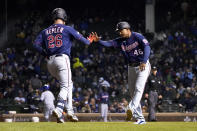 Minnesota Twins third base coach Tony Diaz (46) greets Max Kepler at third after Kepler's home run off Chicago Cubs starting pitcher Kyle Hendricks during the fourth inning of a baseball game Wednesday, Sept. 22, 2021, in Chicago. (AP Photo/Charles Rex Arbogast)