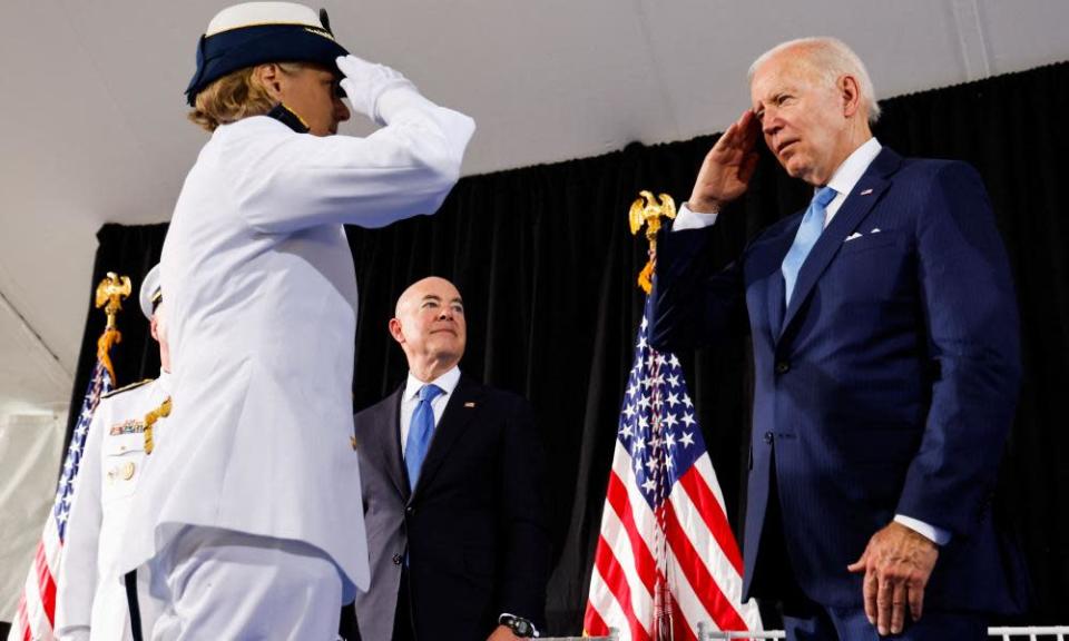 Joe Biden salutes a senior coast guard officer.