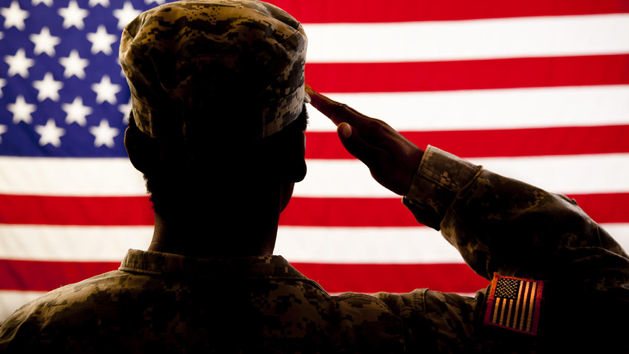 A member of the military salutes the American flag. (Getty Images)