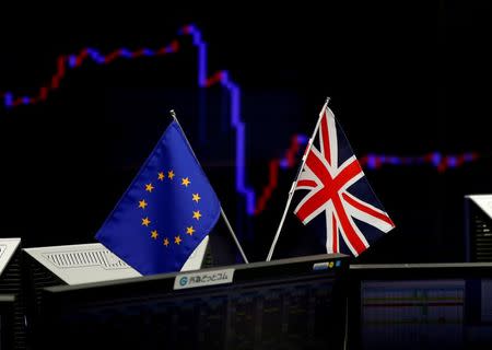 A British flag and an EU flag are seen in front of a monitor displaying a graph of the Japanese yen's exchange rate against the U.S. dollar at a foreign exchange trading company in Tokyo, Japan, June 27, 2016. REUTERS/Toru Hanai