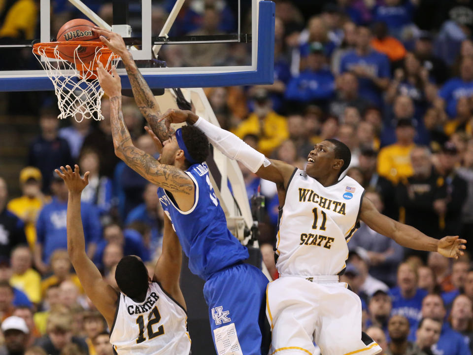 Kentucky forward Willie Cauley-Stein is fouled by Wichita State forward Darius Carter as he dunks the ball in first half action during a Third Round NCAA Tournament game between Wichita State and Kentucky on Sunday, March 23, 2014, at the Scottrade Center in St. Louis. Also defending on the play is Wichita State forward Cleanthony Early, right. (AP Photo/ St. Louis Post-Dispatch, Chris Lee)