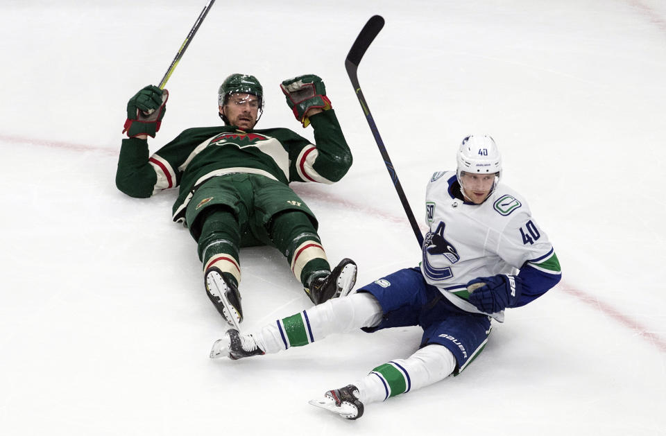 Minnesota Wild's Marcus Foligno (17) and Vancouver Canucks' Elias Pettersson (40) react after colliding during second-period NHL hockey game action in Edmonton, Alberta, Thursday, Aug. 6, 2020. (Jason Franson/The Canadian Press via AP)