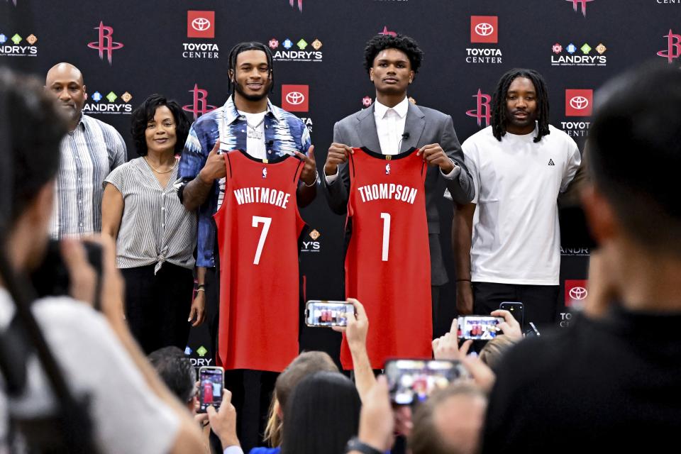 Houston Rockets NBA basketball first-round draft picks Cam Whitmore (7) and Amen Thompson (1) pose with family for a photo during a news conference at the Toyota Center in Houston, Monday, June 26, 2023. (AP Photo/Maria Lysaker)