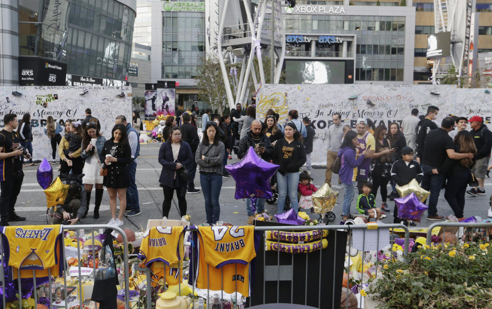 Fans gather at a memorial for the late Kobe Bryant in front of Staples Center in Los Angeles, Sunday, Feb. 2, 2020. Bryant, the 18-time NBA All-Star who won five championships and became one of the greatest basketball players of his generation during a 20-year career with the Lakers, died in a helicopter crash Sunday, Jan. 26. (AP Photo/Damian Dovarganes)