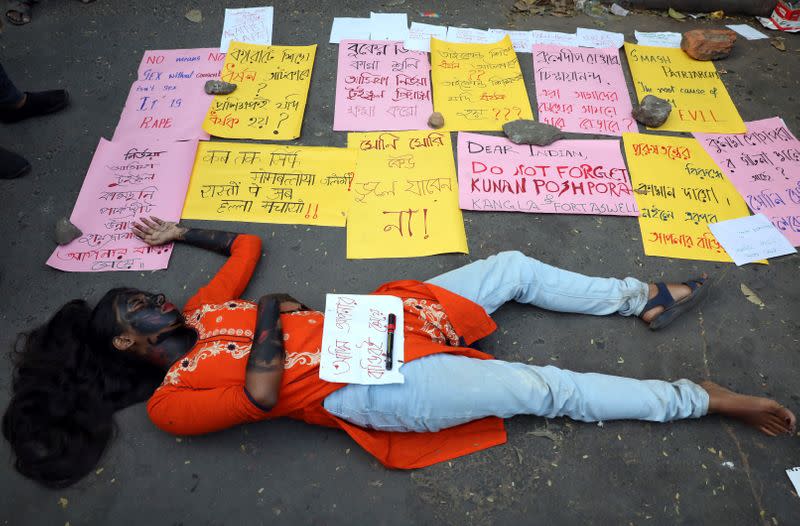 A student lies on the ground as she plays dead during a protest against the alleged rape and murder of a 27-year-old woman, in Kolkata