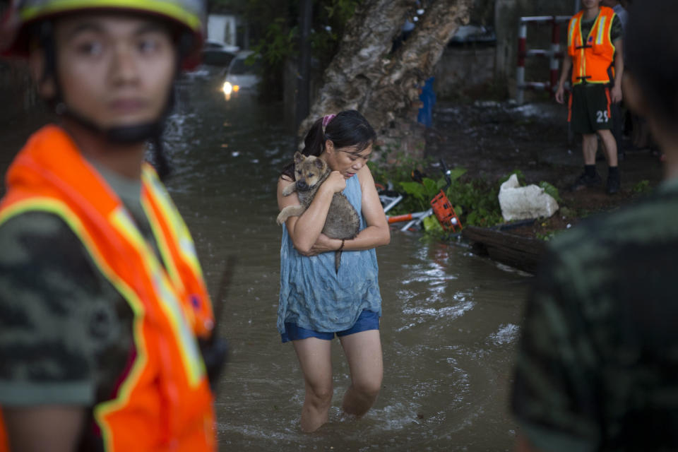 <p>A woman carries her pet in the flooding caused by Typhoon Hato and the astronomical tide on Aug. 23, 2017 in Guangzhou, China. (Photo: Feature China/Barcroft Images/Getty Images) </p>