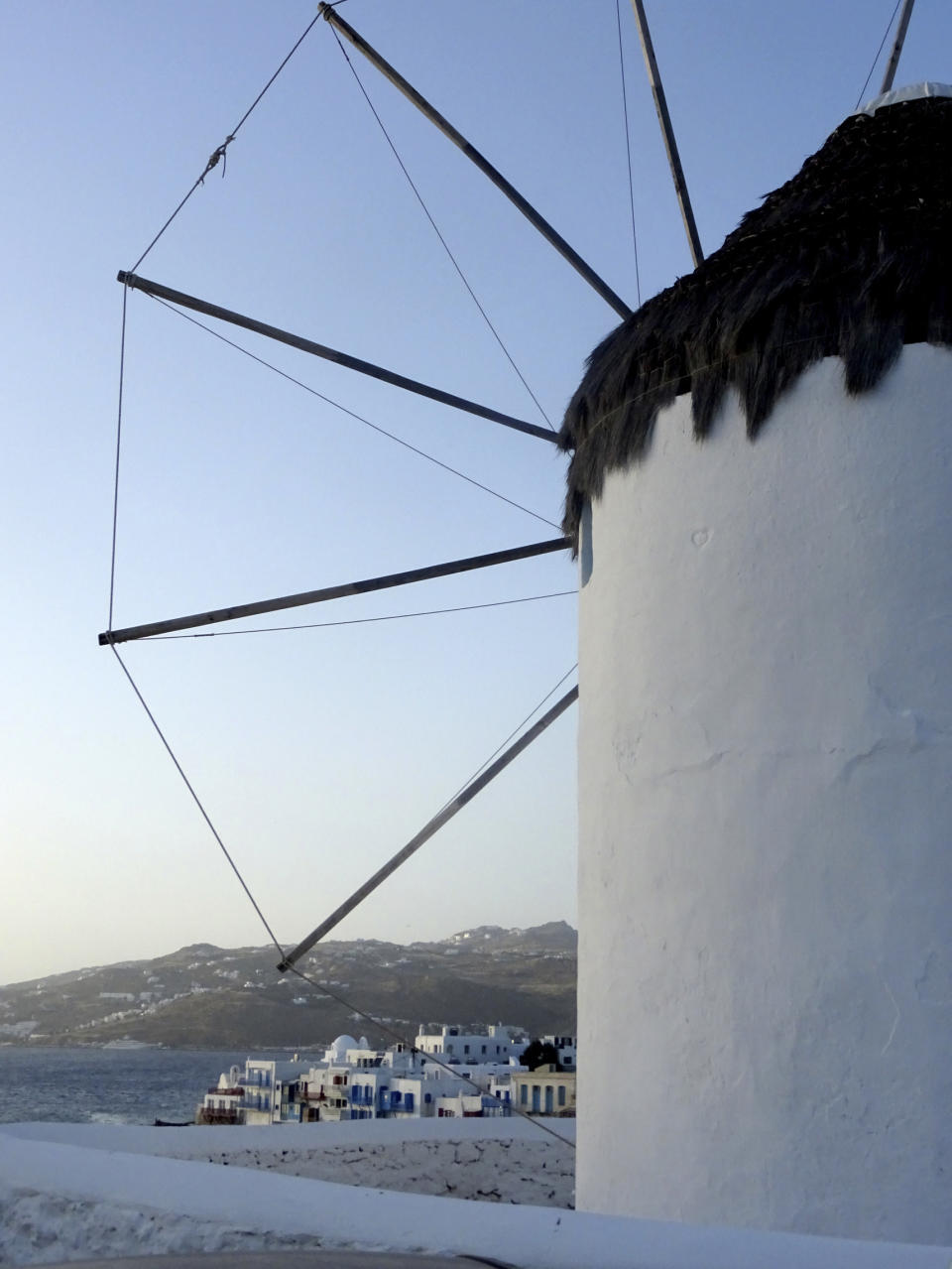 In this Saturday, June 6, 2020 photo a view of a windmill in the main town of the island of Mykonos, Greece. Business owners and locals officials on the Greek holiday island of Mykonos, a popular vacation spot for celebrities, club-goers, and high rollers, say they are keen to reopen for business despite the risks of COVID-19 posed by international travel. Greece will officially launch its tourism season Monday, June 15, 2020 after keeping the country's infection rate low. (AP Photo/Derek Gatopoulos)