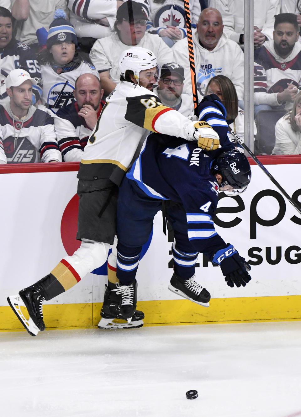 Vegas Golden Knights' Mark Stone (61) checks Winnipeg Jets' Neal Poink (4) during first-period Game 4 NHL Stanley Cup first-round hockey playoff action in Winnipeg, Manitoba, Monday April 24, 2023. (Fred Greenslade/The Canadian Press via AP)
