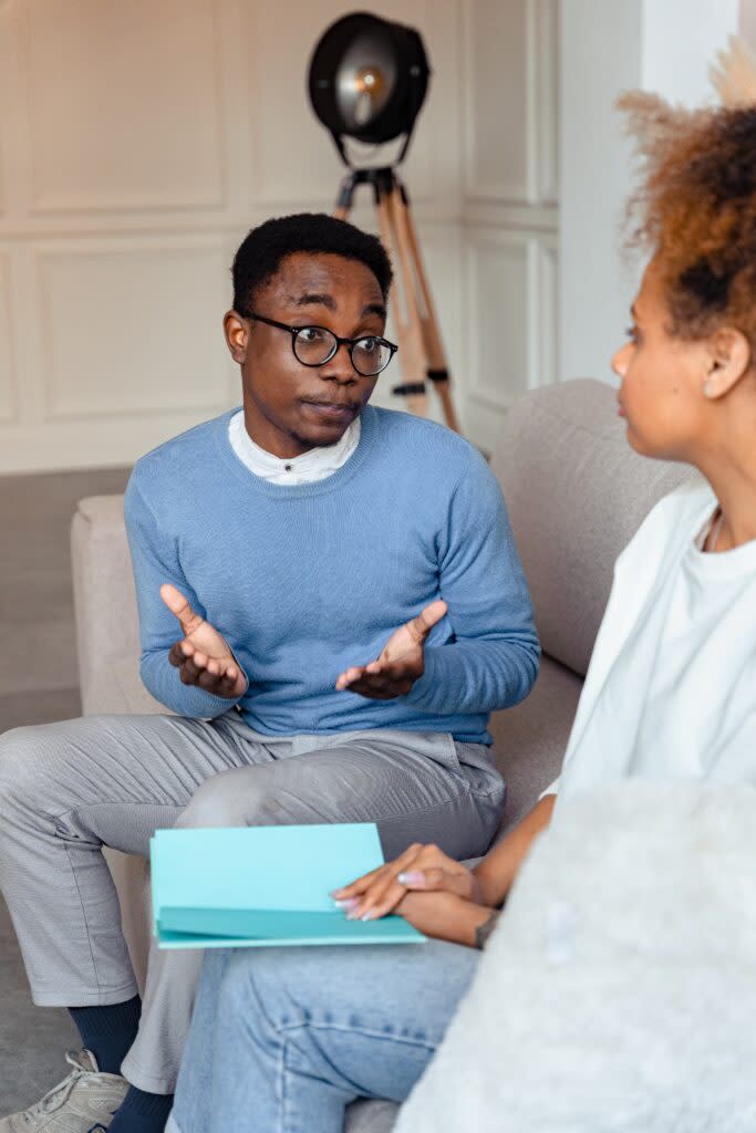 Black couple talking on a couch