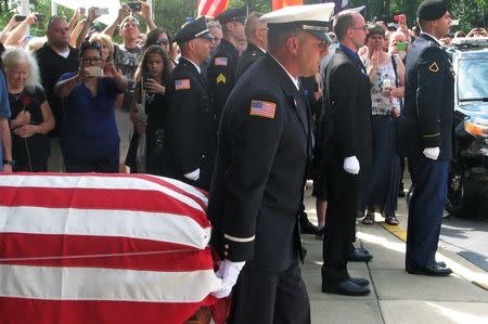 Mourners watch the casket carrying the body of slain police officer Charles Joseph Gliniewicz carried to his funeral in Antioch, Illinois September 7, 2015. REUTERS/Brendan O'Brien