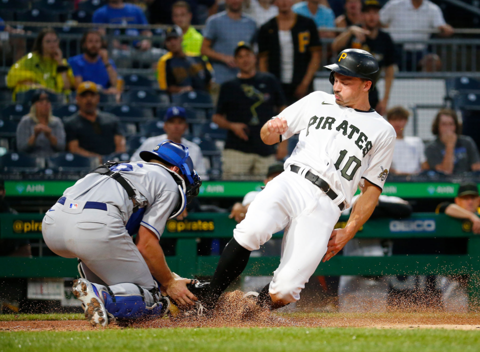 The Pirates' Bryan Reynolds slides safely home against the Dodgers.