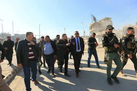 Abdelsattar al-Hibbu, municipality chief of Mosul tours a neighbourhood with members of his team in Mosul, Iraq, January 10, 2018. REUTERS/Ari Jalal/Files