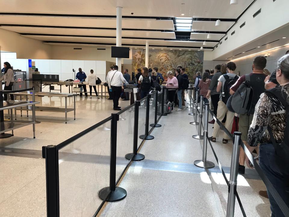 Passengers wait to go through security at the Indianapolis International Airport on Monday, Sept. 23, 2019.