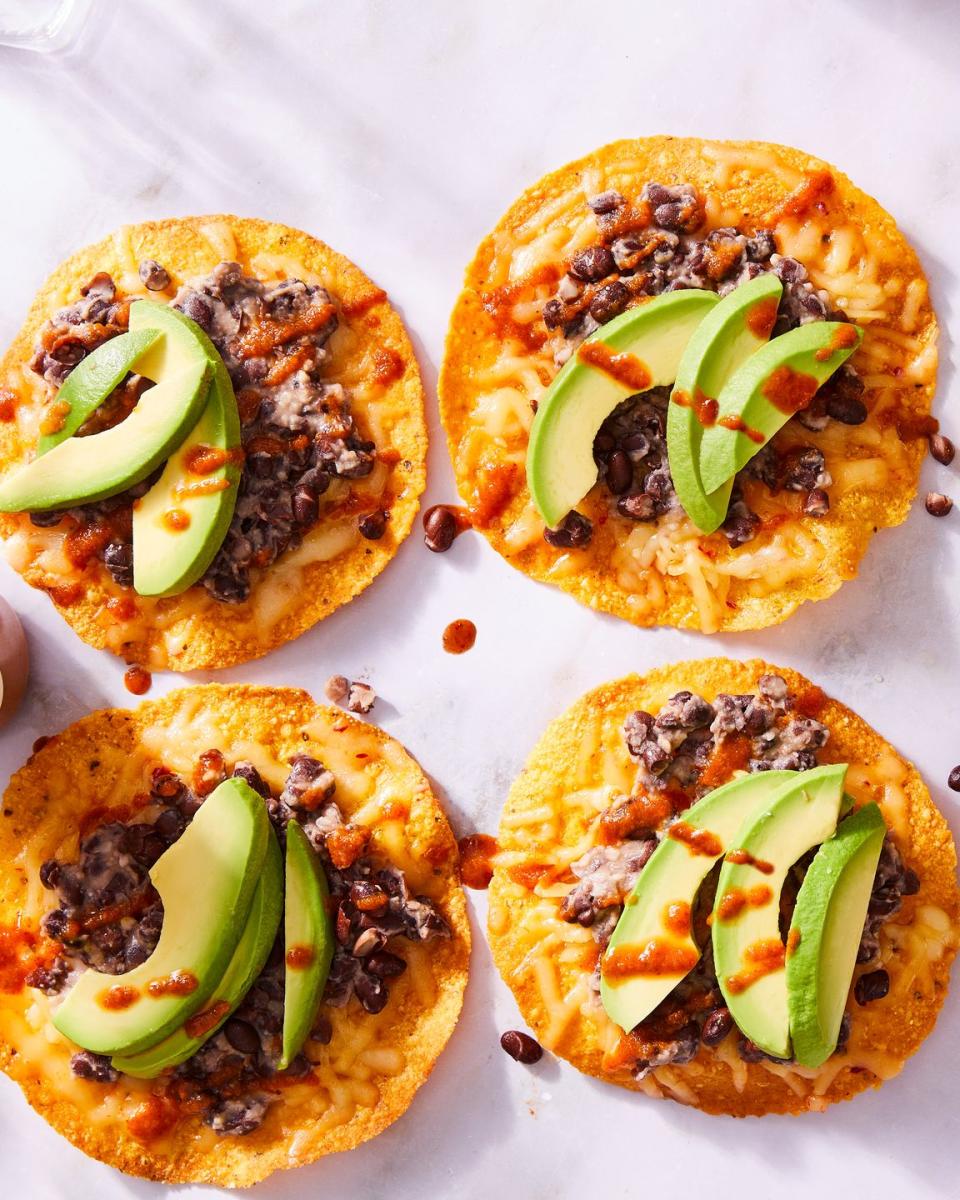 tostadas topped with black beans, cheese, and avocado slices