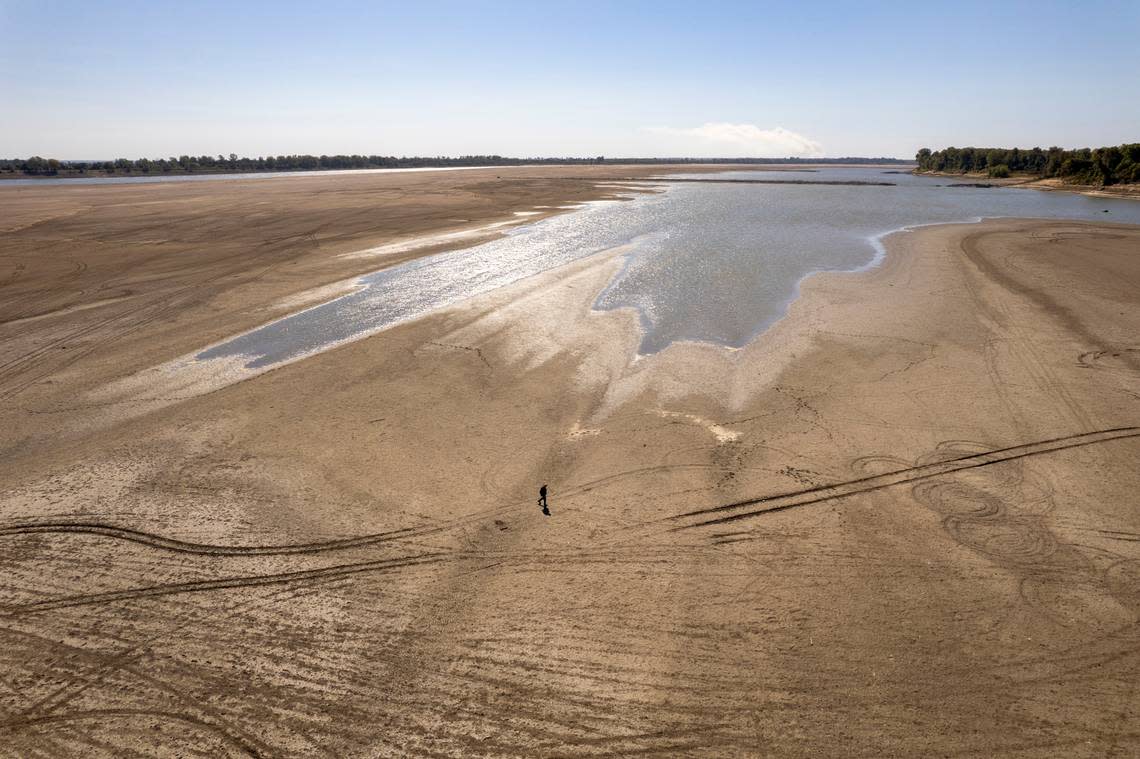 In this photo taken by a drone, James Isaacks walks where the normally wide Mississippi River would flow Thursday, Oct. 20, 2022, near Portageville, Mo. The lack of rainfall in recent weeks has left the river approaching record low levels in areas from Missouri south through Louisiana, making barge and other travel along the river more difficult.