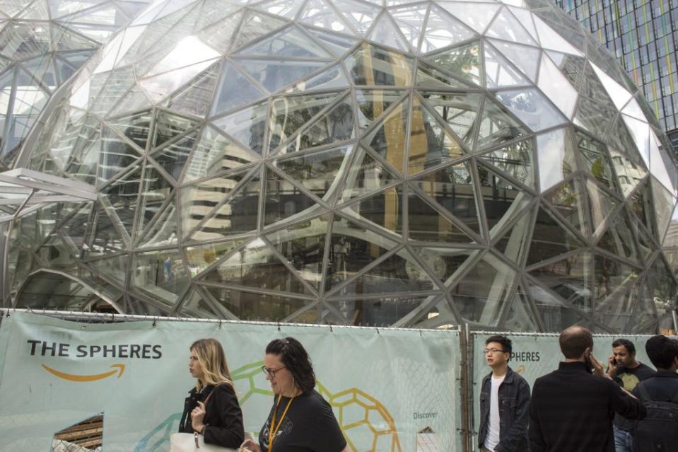 SEATTLE, WA - JUNE 16: People walk past the signature glass spheres under construction at the Amazon corporate headquarters on June 16, 2017 in Seattle, Washington. Amazon announced that it will buy Whole Foods Market, Inc. for over $13 billion. (Photo by David Ryder/Getty Images)