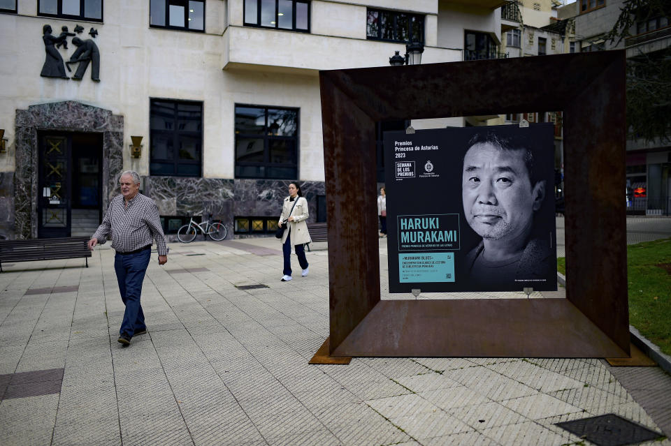 People walk past near a portrait of Japanese author Haruki Murakami in Oviedo, northern Spain, Wednesday, Oct. 18, 2023. Murakami said during an interview with the Associated Press that he is torn by the conflict in Israel since he has Jewish friends but understands that the situation of the Palestinians is dire and that we must pray for peace in Gaza. But he also feels confident that fiction can help us cope with increasingly perilous times by helping readers learn the wisdom found in refraining from making quick judgments. Murakami will receive Spain's Princess of Asturias prize for literature later Friday Oct. 20, 2023. (AP Photo/Alvaro Barrientos)