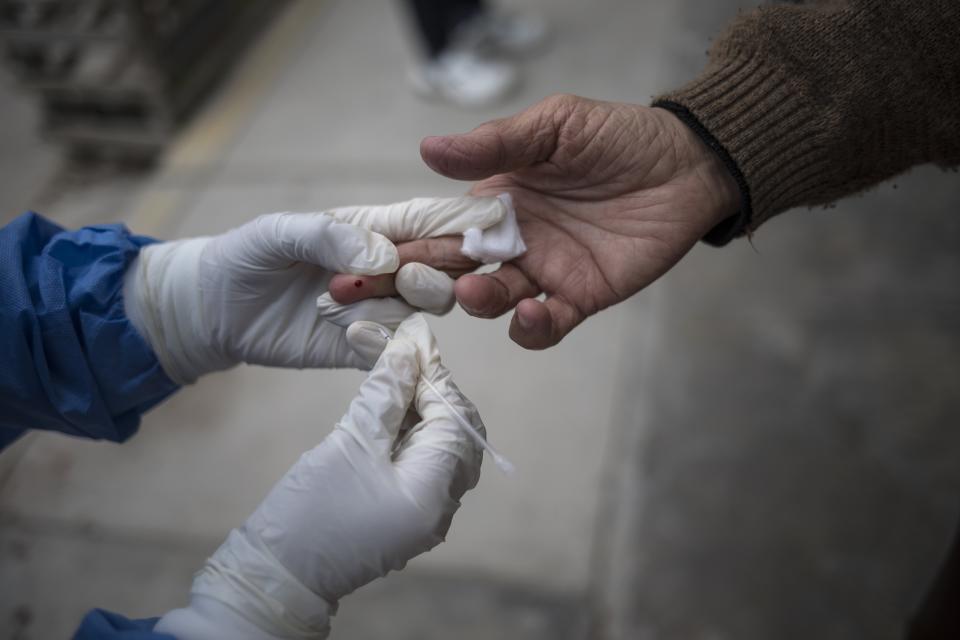 En esta foto de archivo del 30 de junio de 2020, un trabajador de la salud toma una muestra de sangre durante una prueba de manejo rápido de anticuerpos de casa en casa en Villa el Salvador, en las afueras de Lima, Perú. Las pruebas de anticuerpos, que detectan proteínas creadas por el sistema inmunológico en respuesta a un virus, tienen numerosos inconvenientes. Si se toma demasiado pronto, la mayoría de las personas con el virus dan negativo. (Foto AP/Rodrigo Abd, archivo)