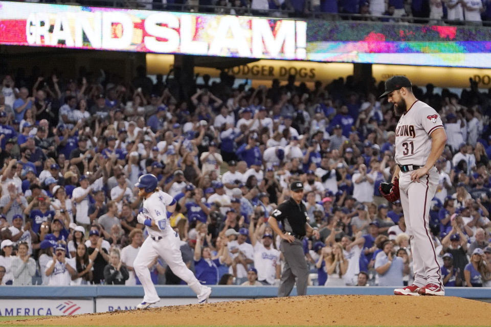 Los Angeles Dodgers' Justin Turner, left, rounds third after hitting a grand slam as Arizona Diamondbacks starting pitcher Caleb Smith stands on the mound during the second inning of a baseball game Saturday, July 10, 2021, in Los Angeles. (AP Photo/Mark J. Terrill)